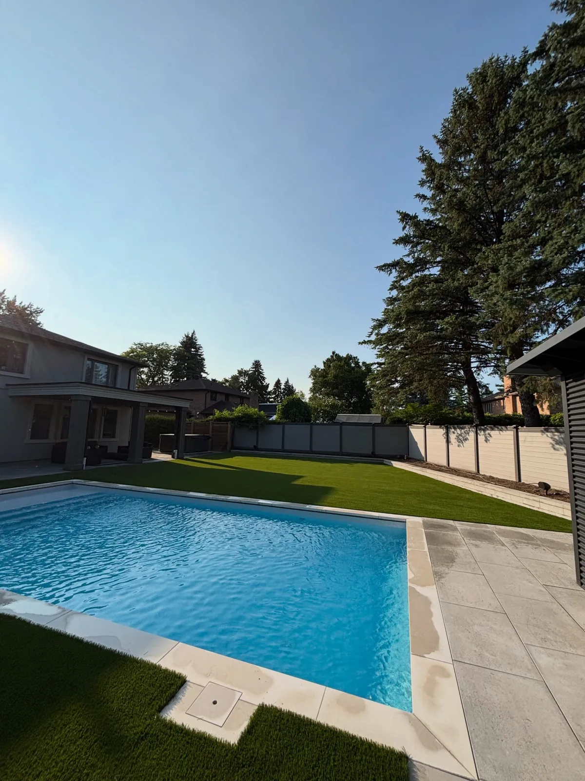 Artificial grass installed around a backyard pool in Whitby